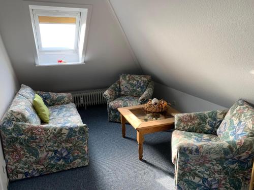 a living room with two chairs and a table at Strandresidenz-Rosengarten-Wohnung-Nr-301 in Büsum