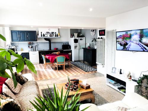 un salon avec une table et une cuisine dans l'établissement La Maison du Bonheur maison de campagne 20 personnes avec jacuzzi, à Anneyron