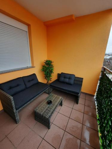 a patio with a couch and a table and a window at Apartman Ares in Osijek