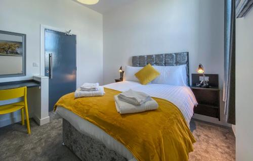 una camera da letto con un grande letto con asciugamani di Piccadilly by Pureserviced a Plymouth