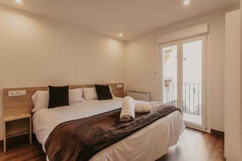 Un dormitorio con una cama grande y una ventana en Apartaments 7Gorgs, en Campdevánol