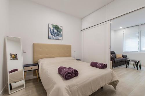 um quarto com uma cama grande e almofadas roxas em 4Torres Homes - Carmen em Madri