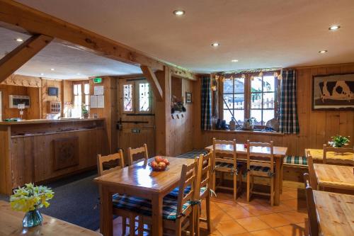 Una cocina y comedor con mesas y sillas de madera. en le Montagny, en Les Houches