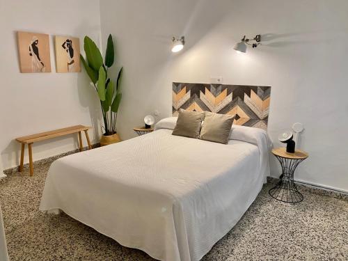 マルベーリャにあるHostal Paco Marbellaのベッドルーム1室(大きな白いベッド1台、テーブル2台付)