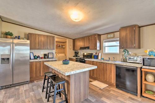 a kitchen with wooden cabinets and a stainless steel refrigerator at 3 Mi to Beach Home with Deck in Port OConnor! in Port O'Connor