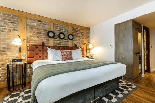 a bedroom with a large bed and a brick wall at Hotel Indigo York by IHG in York