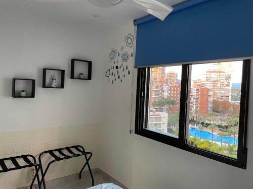 a bedroom with a window with a view of a city at My Sweet Santorini in Benidorm