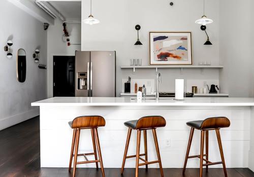 a kitchen with a white counter with two bar stools at The Grant by Black Swan in Savannah