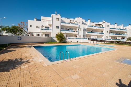 a swimming pool in front of a large building at Apartamento Santa Luzia in Santa Luzia