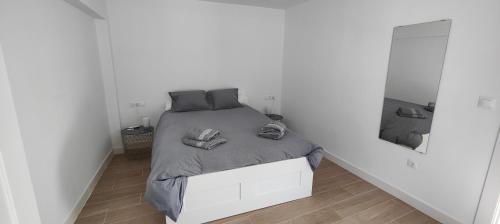 ein weißes Schlafzimmer mit einem Bett in einer weißen Wand in der Unterkunft AOVE TERRACE in Jaén