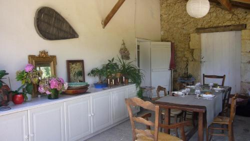 una sala da pranzo con tavolo e frigorifero di Le Château de Roquebère a Condom