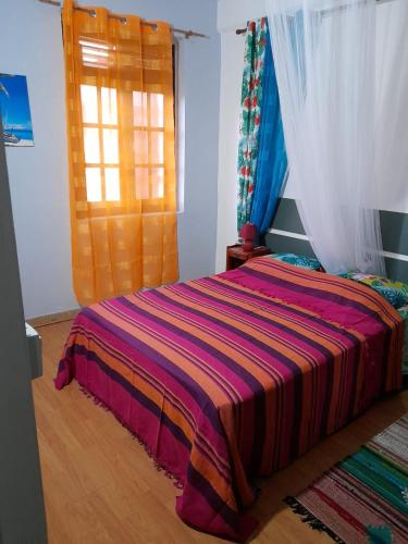 ein Schlafzimmer mit einem Bett mit einer bunten Decke darauf in der Unterkunft Maison de 3 chambres a Saint Pierre a 300 m de la plage avec wifi in Saint-Pierre