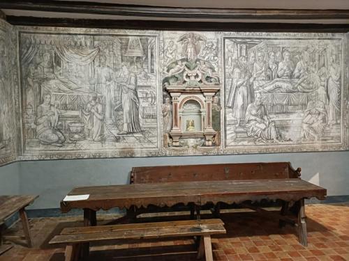 a tapestry hanging on a wall next to a bench at Casa sala pinta in Castellfort