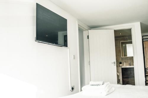 a bedroom with a flat screen tv on a wall at Apartments Dealhouse 4 in Huddersfield
