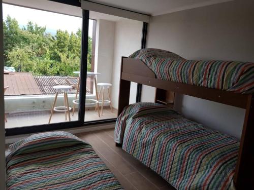 Cette chambre comprend 2 lits superposés et un balcon. dans l'établissement Pewen Apart Hotel Pucón 5, à Pucón