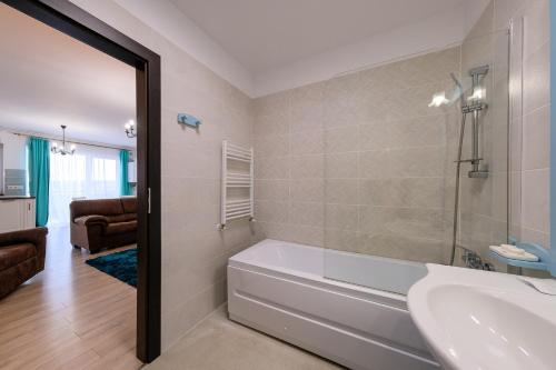 a bathroom with a tub and a sink at Grand Park Turquoise Iulius Mall in Cluj-Napoca