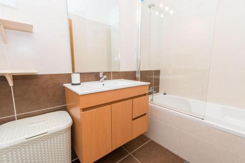 a bathroom with a sink and a tub at Apartamento Santa Luzia in Santa Luzia