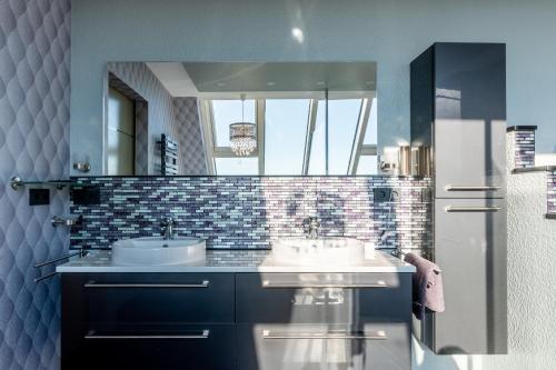 a bathroom with two sinks and a mirror at Zuhause auf Zeit in Osterode