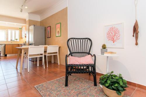 a living room with a chair and a table at Apartamento Santa Luzia in Santa Luzia