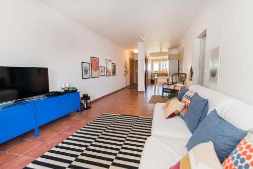 a living room with a white couch and a tv at Apartamento Santa Luzia in Santa Luzia