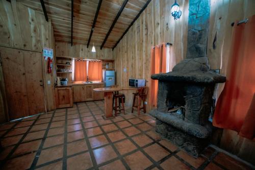 a living room with a fireplace in a cabin at Hotel & Spa Escondite de la Montaña in Sabana Redonda
