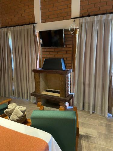 a living room with a piano and a television at Chalé Terrarum in Santo Antônio do Pinhal