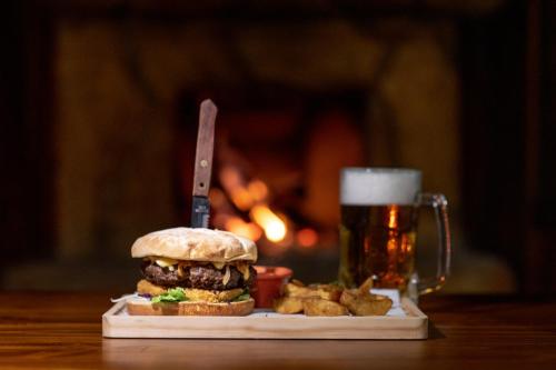 a sandwich and a glass of beer on a table at Hotel & Spa Escondite de la Montaña in Sabana Redonda