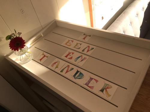 un cajón con letras con un jarrón de flores en 't Een en 't Ander, en Tielt