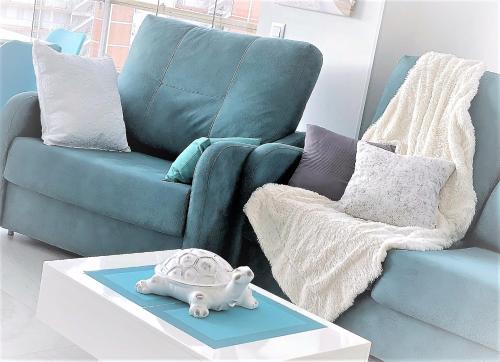 a living room with a couch and a toy turtle on a table at My Sweet Santorini in Benidorm