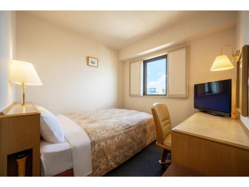 大仙市にあるGreen Hotel Omagari - Vacation STAY 19285vのベッド1台、薄型テレビが備わるホテルルームです。