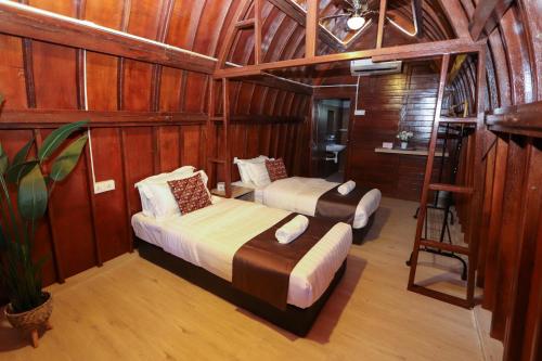 a room with two beds and a ladder in it at 8 Wooden Inn LOT 1806 in Kampong Alor Gajah