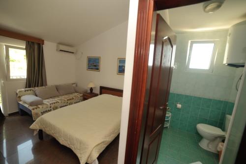 a small bedroom with a bed and a bathroom at Mijovic Apartments in Budva