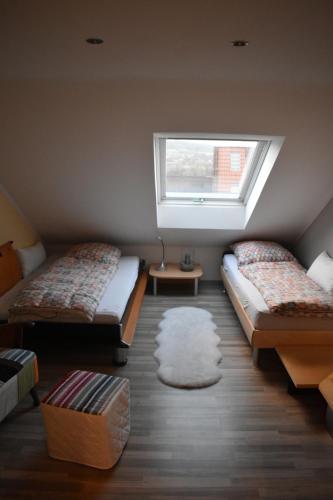 a small room with two beds and a window at Ferienwohnung 360° in Himmelkron