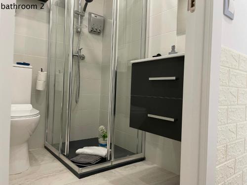 a shower with a glass door in a bathroom at My Sweet Santorini in Benidorm
