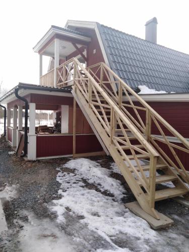 a house with a wooden staircase on the side of it at Persbacken i naturnära Ockelbo med fiske o Kungsberget när inpå,,, in Ockelbo