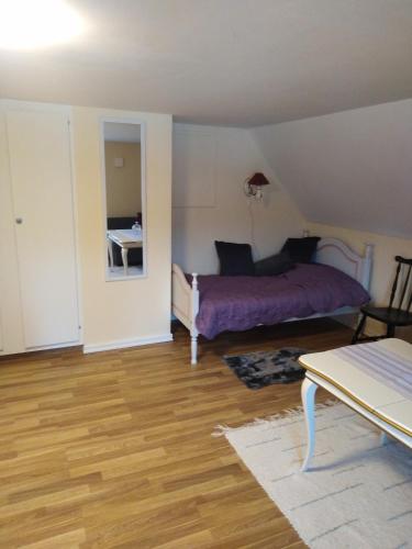Un dormitorio con una cama y una mesa. en Persbacken i naturnära Ockelbo med fiske o Kungsberget när inpå,,,, en Ockelbo