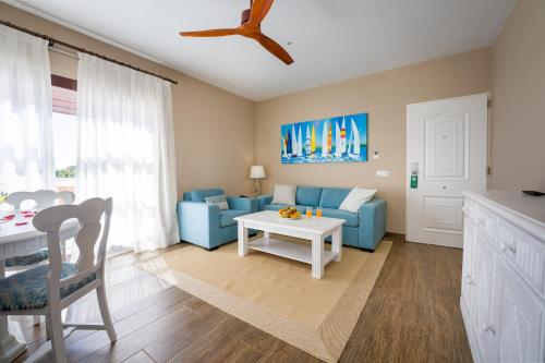 a living room with a blue couch and a table at LANZAROTE PRIME SPORTS by Vitalclass Lanzarote Resort in Costa Teguise
