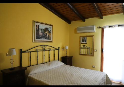 1 dormitorio con cama y pared amarilla en Samoa Beach en Arenella