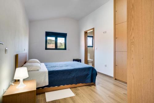 a bedroom with a bed with a blue bedspread at Areias Village in Vale de Cambra