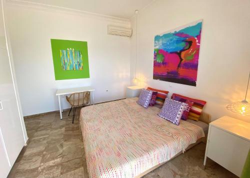 a bedroom with a bed and a painting on the wall at The Beachhouse Apartments in Vaia