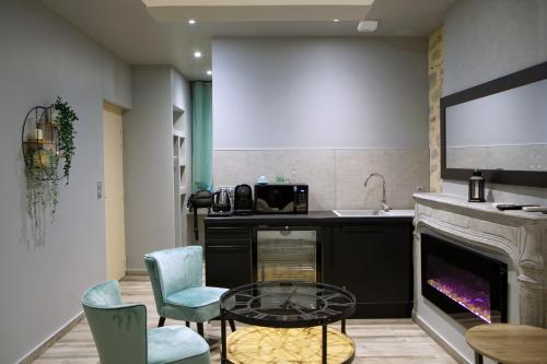 a living room with a fireplace and a table and chairs at LA DOLCEVITA SPA Suite privative in Besançon