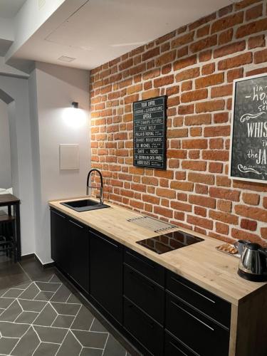 a kitchen with a brick wall and a counter top at Boogie Deluxe Old Town in Wrocław