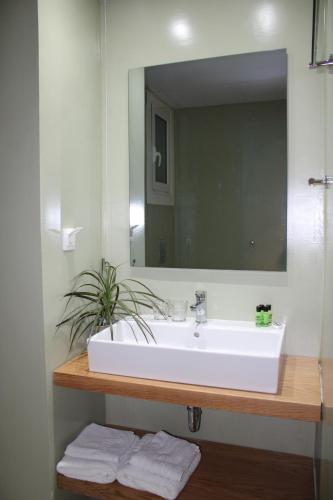 a bathroom with a white sink and a mirror at Dassia Beach Hotel in Dassia