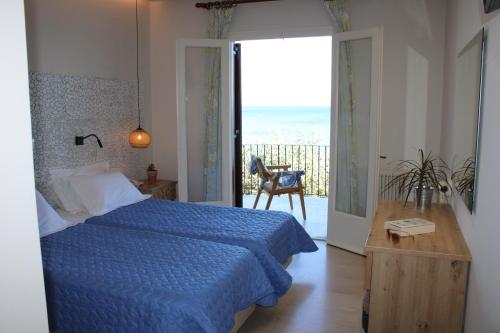 a bedroom with a blue bed and a view of the ocean at Dassia Beach Hotel in Dassia