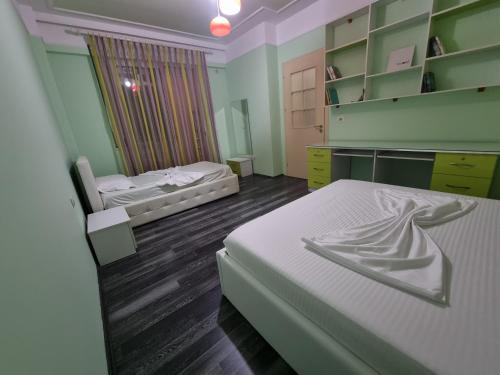 a small bedroom with two beds and a mirror at MoonShine Apartament in Tirana