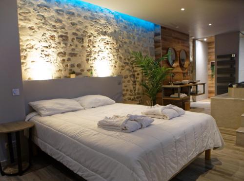 a bedroom with a bed with towels on it at LA DOLCEVITA SPA Chambre privative in Besançon