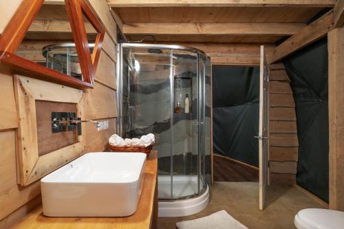 a bathroom with a shower and a white tub at Altura Hotel in Poasito