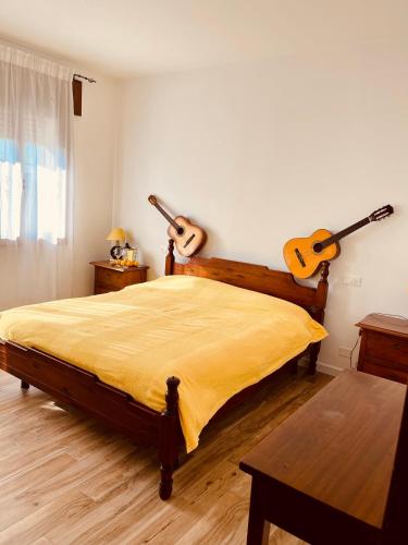 a bedroom with a bed with two guitars on the wall at Ottavanota in Bassano del Grappa