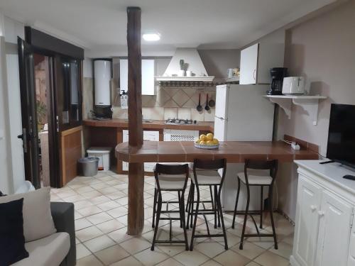 uma cozinha com uma mesa e alguns bancos de bar em Apartamento en sanxenxo duplex em Sanxenxo