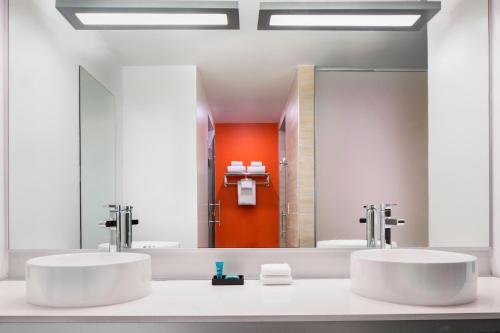 a bathroom with two sinks and a large mirror at Aloft Fort Worth Downtown in Fort Worth